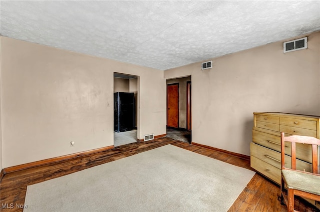 interior space featuring dark hardwood / wood-style flooring and a textured ceiling