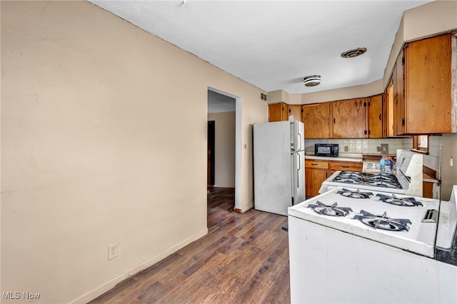 kitchen with tasteful backsplash, refrigerator, stove, white gas range, and dark hardwood / wood-style flooring