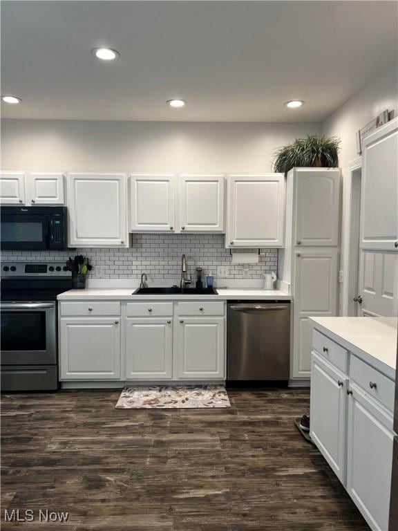 kitchen with white cabinets, dark hardwood / wood-style flooring, sink, and stainless steel appliances