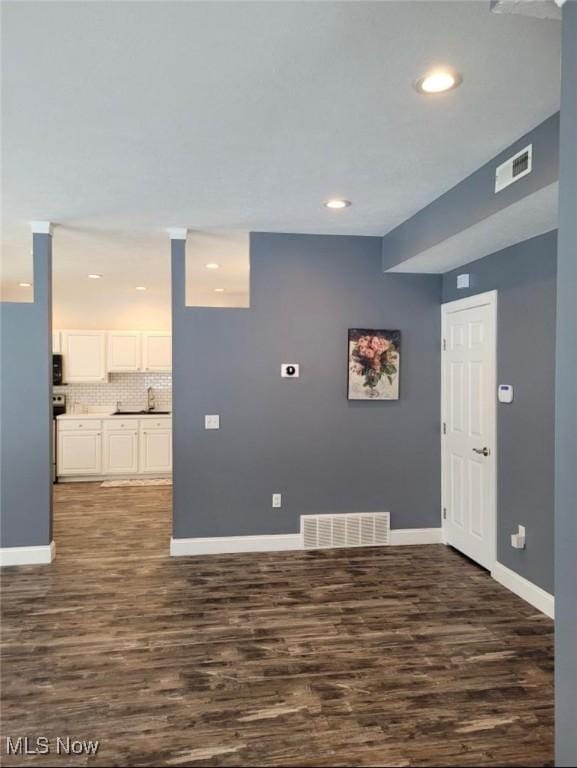 empty room featuring sink and dark hardwood / wood-style flooring