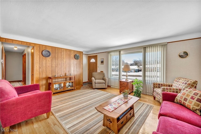 living room featuring wooden walls and light hardwood / wood-style flooring