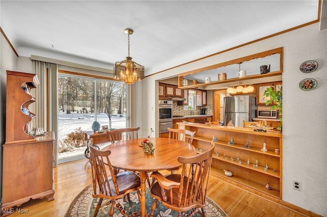 dining area featuring an inviting chandelier and light hardwood / wood-style flooring