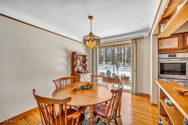 dining room featuring a chandelier, light hardwood / wood-style floors, and ornamental molding