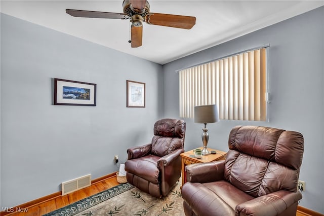 living area with ceiling fan and hardwood / wood-style flooring