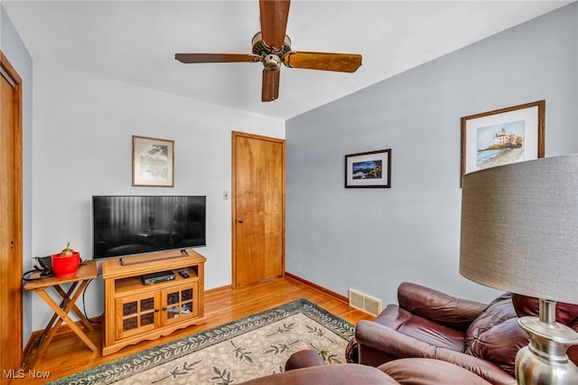 living room with ceiling fan and light wood-type flooring