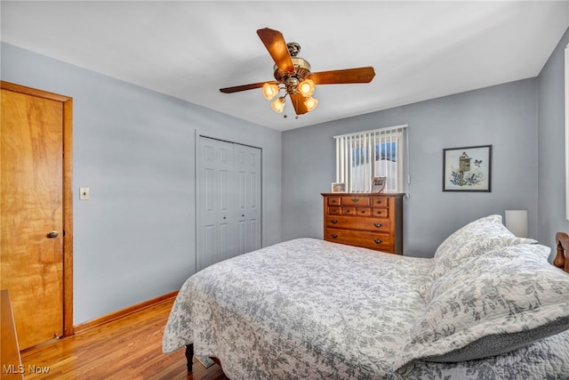 bedroom with ceiling fan, light hardwood / wood-style floors, and a closet