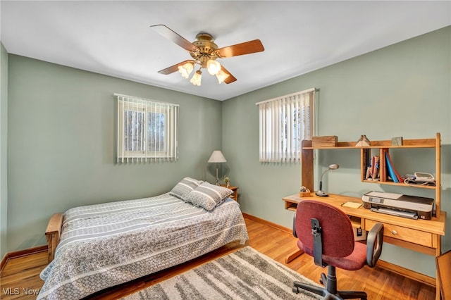 bedroom with ceiling fan and hardwood / wood-style flooring