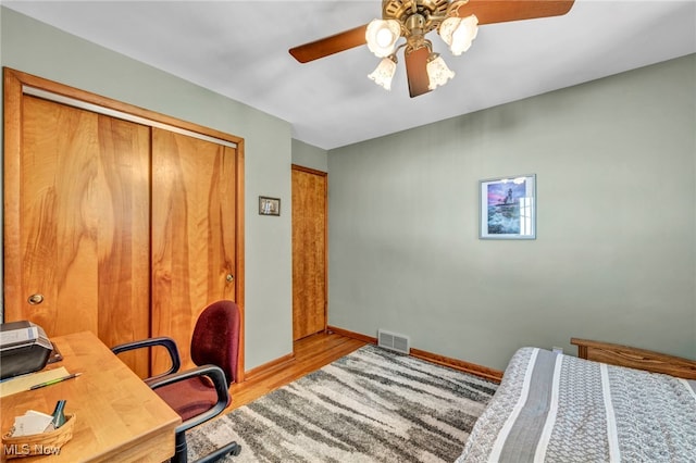 bedroom featuring ceiling fan, light hardwood / wood-style flooring, and a closet