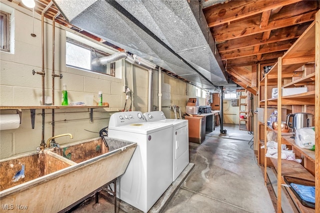 basement featuring separate washer and dryer and sink