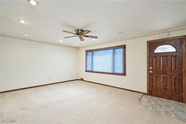 carpeted entryway with ceiling fan and a wealth of natural light