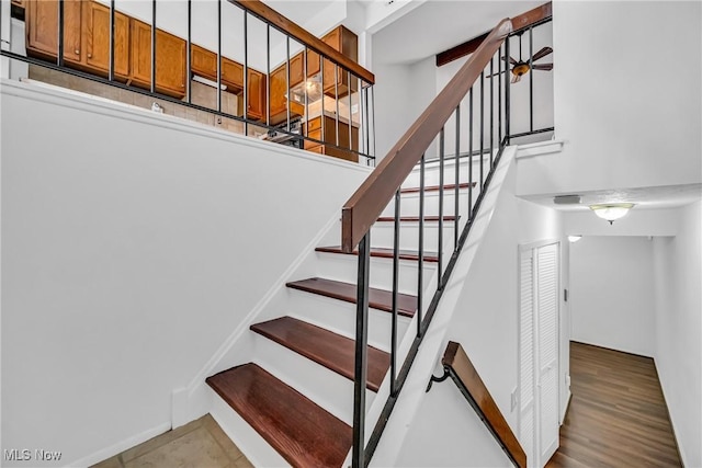 stairs featuring ceiling fan