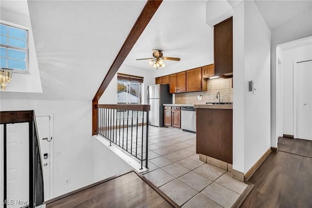 kitchen with ceiling fan, sink, appliances with stainless steel finishes, and tasteful backsplash