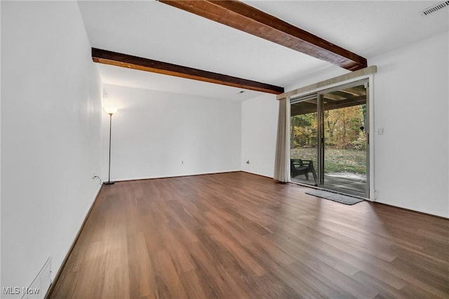 unfurnished room with beamed ceiling and hardwood / wood-style floors