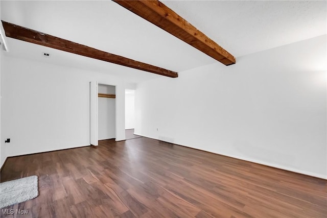 unfurnished living room with dark hardwood / wood-style flooring and beam ceiling