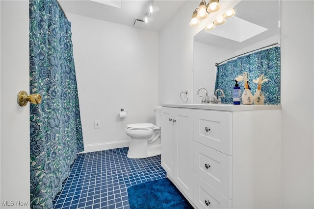 bathroom featuring toilet, a skylight, tile patterned flooring, and vanity