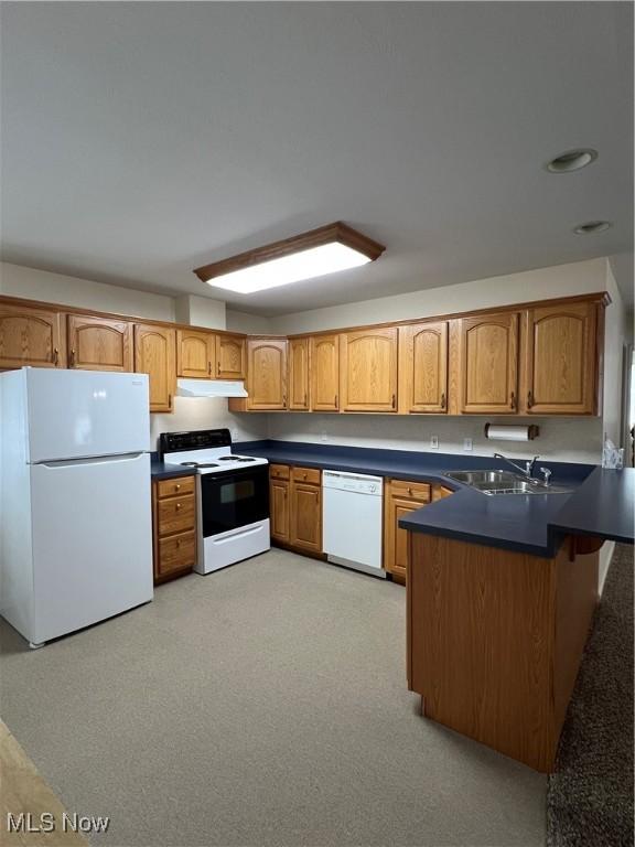 kitchen with sink, kitchen peninsula, and white appliances