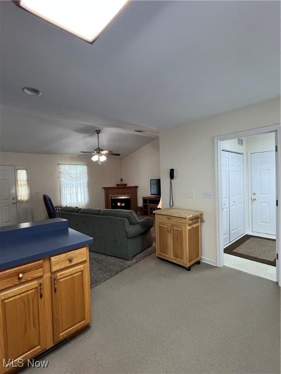 carpeted living room featuring ceiling fan and lofted ceiling