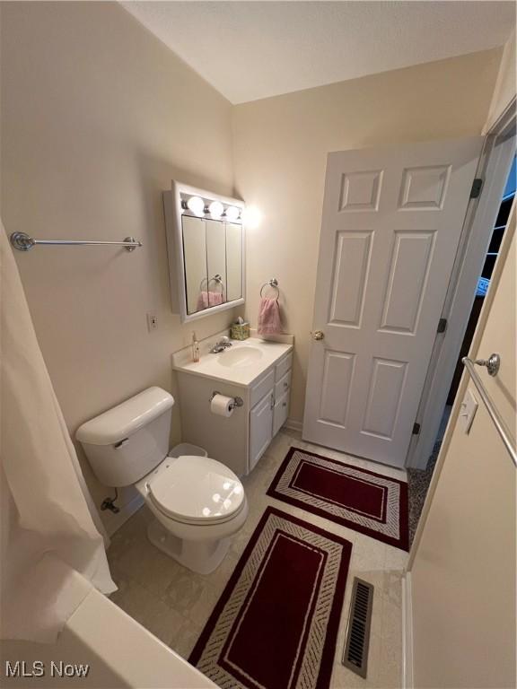 bathroom featuring toilet, tile patterned flooring, and vanity