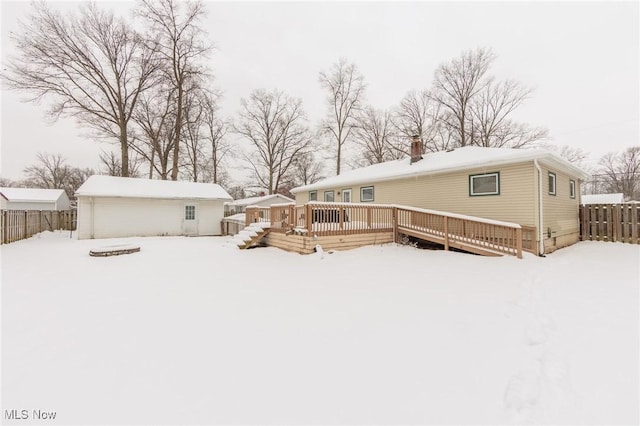 snow covered house with a wooden deck