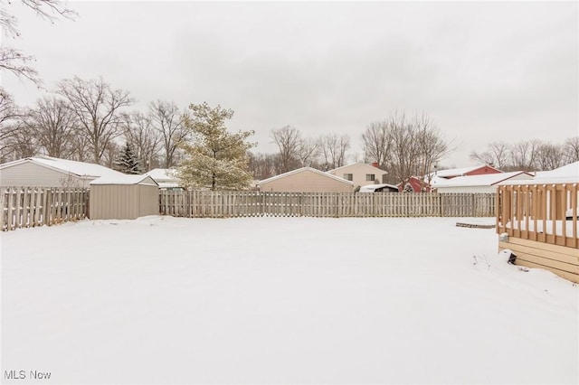 yard covered in snow with a storage shed