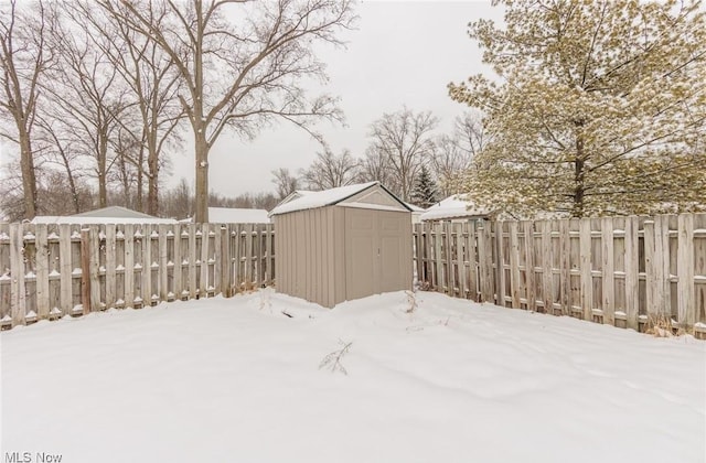 yard covered in snow with a storage unit