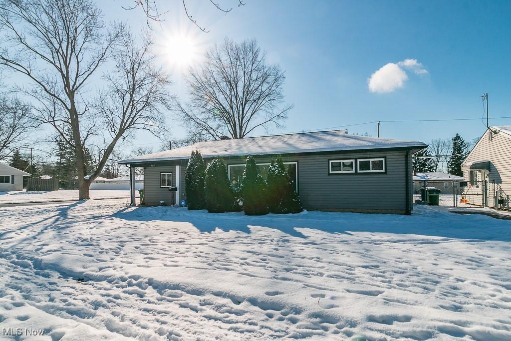 view of snow covered back of property