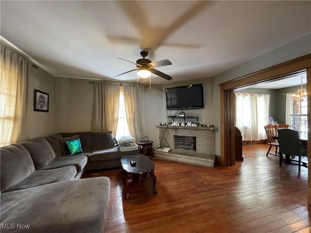 living room with wood-type flooring and ceiling fan with notable chandelier