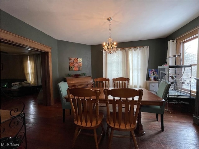 dining area featuring dark wood-type flooring and a chandelier