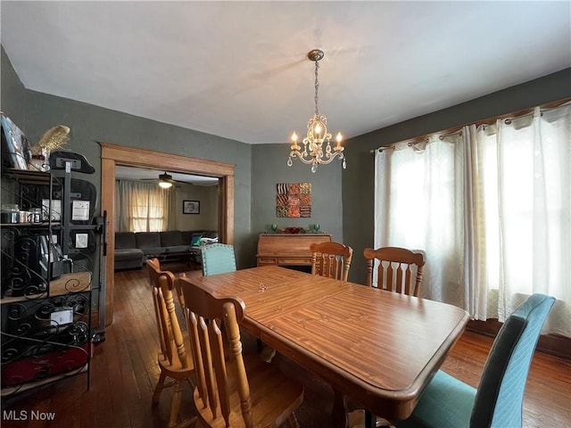 dining space featuring an inviting chandelier and dark wood-type flooring