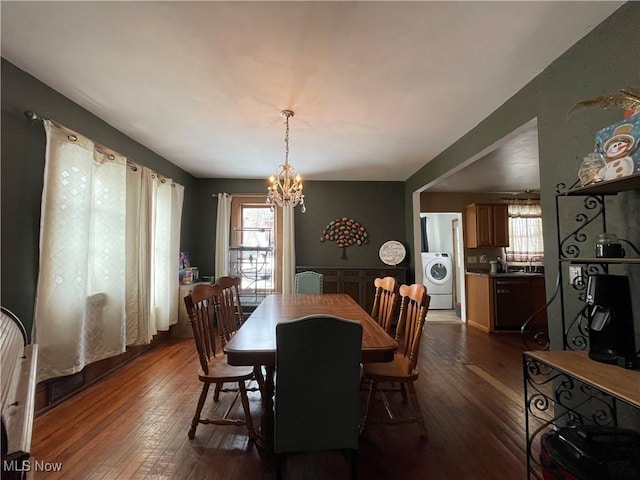 dining space with washer / dryer, dark wood-type flooring, and a chandelier