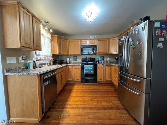 kitchen featuring stone countertops, sink, hardwood / wood-style flooring, black appliances, and light brown cabinets