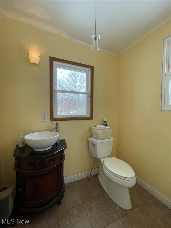 bathroom with vanity, tile patterned flooring, ornamental molding, and toilet