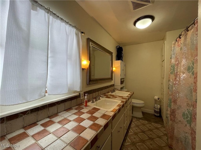 bathroom featuring a shower with curtain, vanity, and toilet