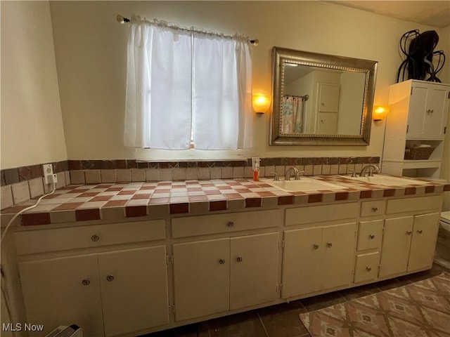 bathroom featuring vanity, tile patterned floors, and toilet