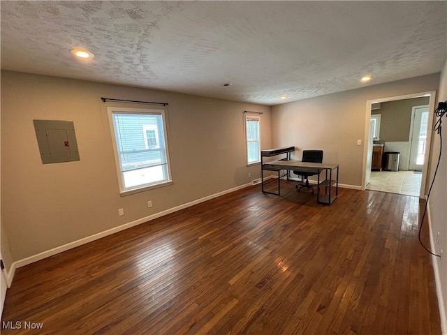 office featuring dark hardwood / wood-style floors, a textured ceiling, and electric panel