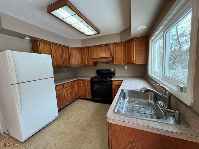 kitchen with custom exhaust hood, white fridge, sink, black gas stove, and light tile patterned floors