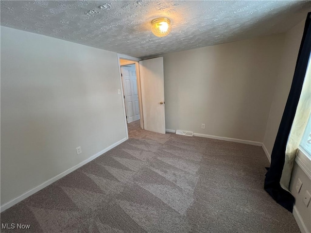 carpeted spare room featuring a textured ceiling