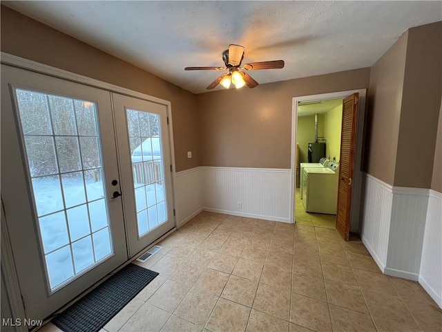 doorway to outside featuring water heater, ceiling fan, washer and dryer, light tile patterned flooring, and french doors