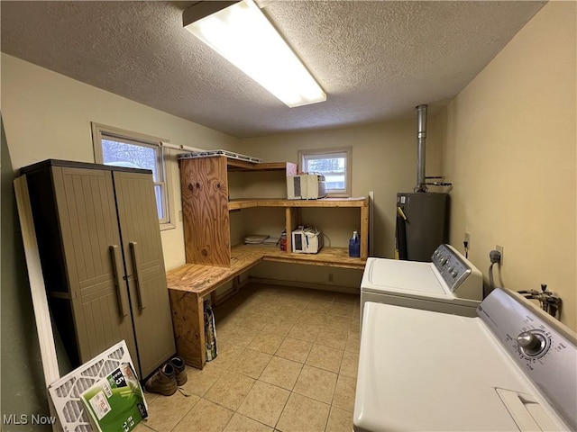 clothes washing area with a textured ceiling, washer and dryer, light tile patterned flooring, and gas water heater