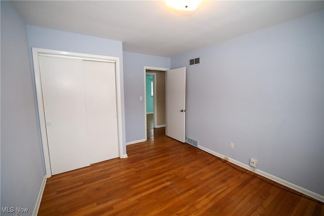 unfurnished bedroom featuring hardwood / wood-style flooring and a closet