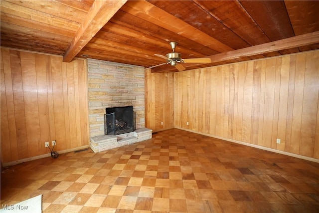 unfurnished living room featuring beamed ceiling, wood walls, and wooden ceiling