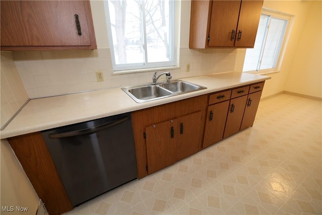 kitchen featuring decorative backsplash, dishwasher, and sink