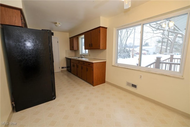 kitchen featuring decorative backsplash, sink, and black appliances