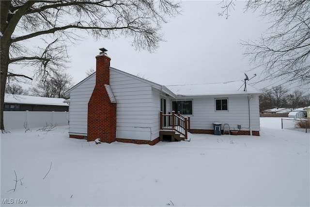 view of snow covered back of property