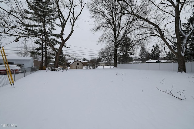 yard layered in snow with a shed