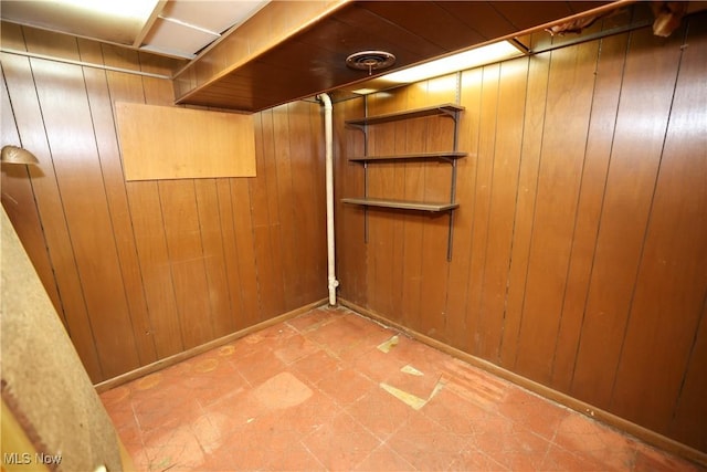 basement featuring wooden walls