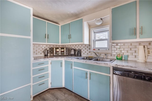 kitchen featuring stainless steel dishwasher, hardwood / wood-style flooring, backsplash, and sink