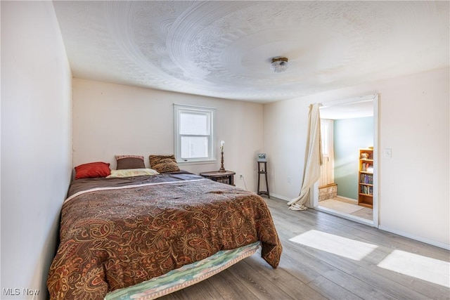 bedroom featuring light wood-type flooring and a textured ceiling