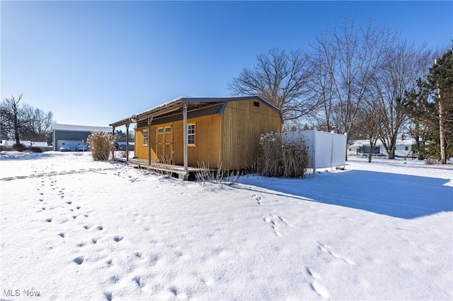 view of snow covered exterior featuring an outbuilding