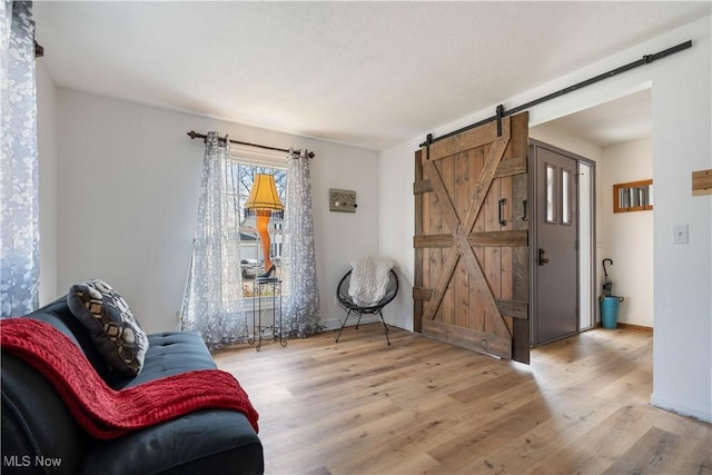 living area with a barn door and light wood-type flooring